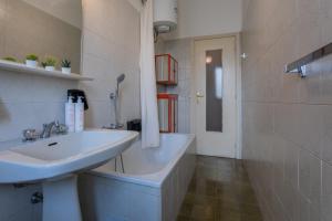 a bathroom with a sink and a bath tub at Little Peschiera by Wonderful Italy in Turin