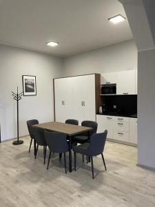 a dining room with a table and chairs and a kitchen at Apartamenty Delux-S1 przy trasie S1 in Łodygowice