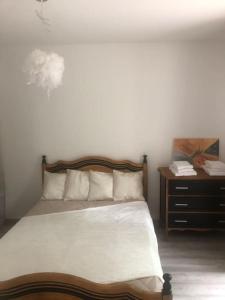 um quarto com uma cama e uma cómoda com uma mesa de cabeceira em Appartement en pleine forêt em Sainte-Hélène
