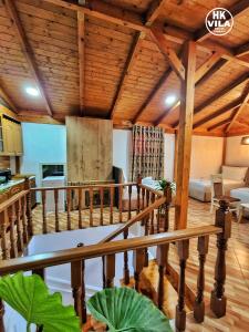 a living room with wooden ceilings and a wooden staircase at Vila HK in Krujë