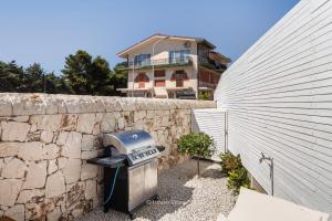 a stone wall with a grill next to a building at Oasi Sicula in Avola
