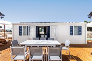 a white house with a table and chairs on a deck at Oasi Sicula in Avola