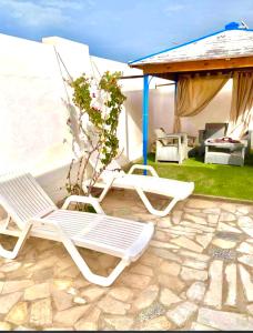 two lawn chairs and a gazebo with a table at Holiday home by the sea, Gabes in Gabès