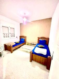 - 2 lits dans une chambre avec des draps bleus dans l'établissement Holiday home by the sea, Gabes, à Gabès