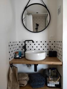 La salle de bains est pourvue d'un lavabo et d'un miroir. dans l'établissement Studio à Bellegarde, à Bellegarde