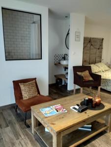 - un salon avec une table en bois et 2 chaises dans l'établissement Studio à Bellegarde, à Bellegarde