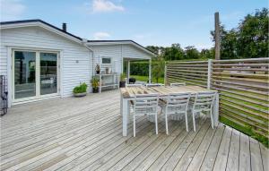 une terrasse en bois avec une table et des chaises. dans l'établissement 3 Bedroom Lovely Home In Eldsberga, à Eldsberga