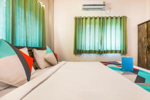 ein Schlafzimmer mit einem großen Bett mit bunten Kissen in der Unterkunft FabExpress Diamond Residency in Pune