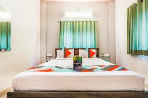 a bedroom with a large bed with colorful pillows at FabExpress Diamond Residency in Pune