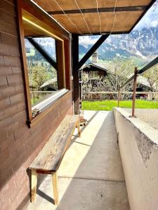 a wooden bench sitting on a porch with a window at Chalet Sonnenheim, Wohnung mit Panoramafenster in Adelboden