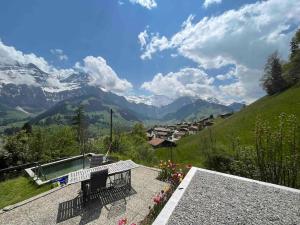 a patio with a bench and a view of mountains at Chalet Sonnenheim, Wohnung mit Panoramafenster in Adelboden
