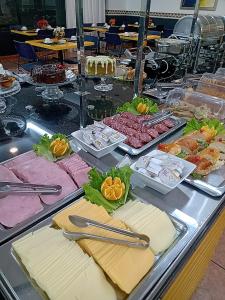 ein Buffet mit verschiedenen Speisen auf dem Tisch in der Unterkunft Mogano Business Hotel- ELETROPOSTO in Chapecó