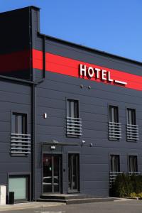 a hotel with a red sign on the side of it at M&W Hotel Wronowski in Łomża