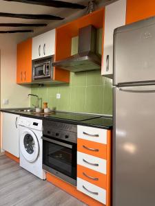 a kitchen with orange and white cabinets and a refrigerator at Charming apartment in the heart of Madrid in Madrid