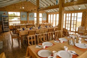 a dining room with tables and chairs and windows at Nature Door Resort, Khuvsgul province, Mongolia 