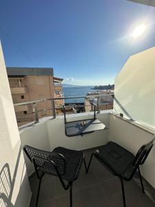 a balcony with two chairs and a view of the ocean at Villa Idrizi in Sarandë