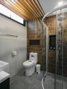 W łazience znajduje się toaleta i przeszklony prysznic. w obiekcie Maesa Greenery Hill SHA w mieście Mae Rim