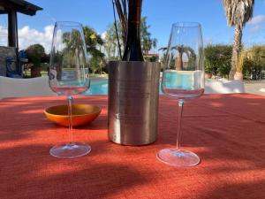 twee wijnglazen zittend op een tafel met een fles wijn bij The Bamboo villa in Casale la Cogna