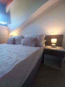 ein Schlafzimmer mit einem großen weißen Bett mit einer Lampe in der Unterkunft Il Riccio home & relax in Riccia