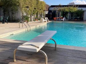 a white bench sitting next to a swimming pool at The Bamboo villa in Casale la Cogna