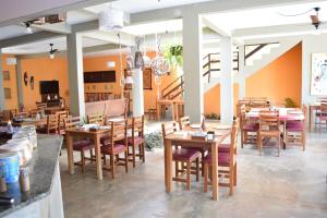 comedor con mesas y sillas de madera en Pousada Só Alegria, en São Miguel do Gostoso