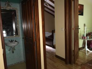 a bathroom with a sink and a mirror at Cabaña Pasiega "La Reina del Paraíso" in San Roque de Ríomiera