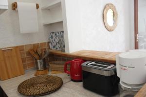 a kitchen with a counter with a coffee maker on the floor at T2 climatisé à 2 minutes de la plage du Pont Tournant - 4BRANR in Saint-Cyprien-Plage