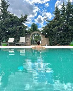 uma pessoa na água numa piscina em Masseria Casina Montana em Corigliano dʼOtranto