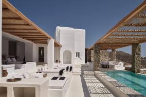 a villa with a swimming pool and white furniture at Villa La Piscine Mykonos in Houlakia