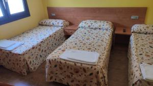 een hotelkamer met 2 bedden en een tafel bij Pension Urola in Zumárraga