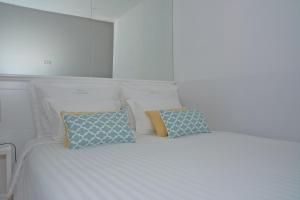 a white bed with white pillows and pillows at Bolhão Nobre Apartments in Porto