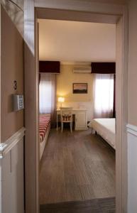 a room with two beds and a table and a desk at Bed Bra in Verona