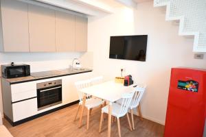 Il comprend une cuisine équipée d'une table et d'un réfrigérateur rouge. dans l'établissement Garofoli Apartments, à San Giovanni Lupatoto