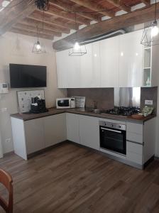 a kitchen with white cabinets and a stove top oven at Monolocale Lucca PellegriniLittleHouse in Lucca