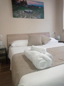 two beds with white towels on them in a room at Monolocale Lucca PellegriniLittleHouse in Lucca +35 photos