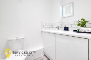 a white bathroom with a sink and a mirror at SCA- Arden Apartment 8 Twin Bedroom Free Parking in Coventry