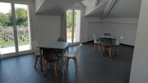 a room with two tables and chairs and windows at La casa al mare di MatiGiò in Pietra Ligure