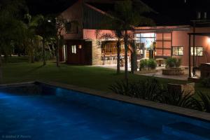 a swimming pool in front of a house at night at Momora distrito selva in Santa Ana