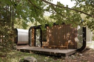 uma casa coberta de madeira com duas cadeiras e árvores em Chalets & Apartments - Base Camp Medvědín em Špindlerŭv Mlýn