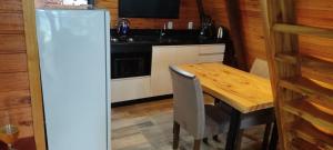 uma cozinha com uma mesa de madeira e um frigorífico em CABANAS DA MATA NP em Nova Petrópolis