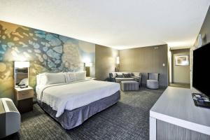 ヒューストンにあるCourtyard Houston I-10 West/Energy Corridorの大きなベッドとソファが備わるホテルルームです。