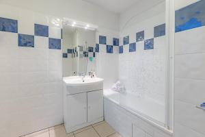 a white bathroom with a sink and a shower at Appart'City Classic Toulouse Tournefeuille in Tournefeuille