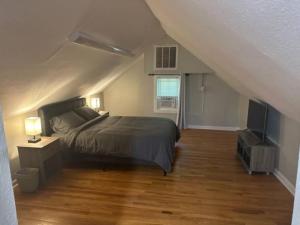 um quarto com uma cama e uma televisão num sótão em 6 BR Home near Football Stadium! em Greenville