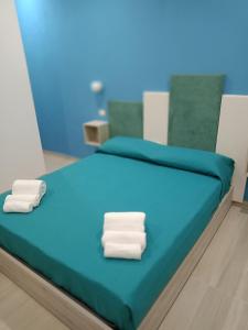 uma cama de hospital com duas toalhas brancas em Mary's rooms em Parghelia