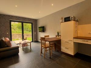 a kitchen and living room with a table and a microwave at Ferienwohnung Am Weiher Kategorie 2 in Nideggen