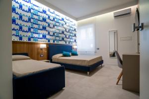 a bedroom with two beds and a blue wall at Cuore di Minori in Minori