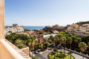 Blick auf eine Stadt mit Palmen und das Meer in der Unterkunft Sur Suites Torrequebrada in Benalmádena
