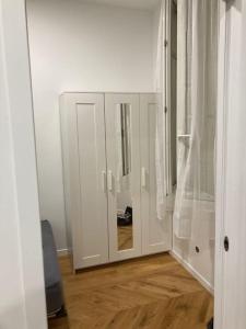 een witte kast met een spiegel in een kamer bij Appartement confortable et complet in Clichy
