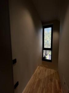 um quarto com piso em madeira e uma janela em Savour Villas Kayaköy em Fethiye