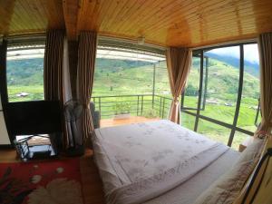 ein Schlafzimmer mit einem Bett und einem großen Fenster in der Unterkunft Amica House in Sa Pa